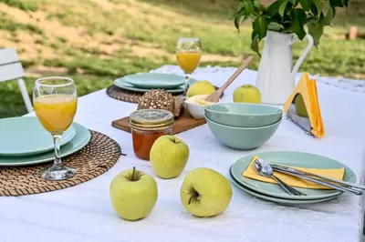 a table with plates of apples and glasses of juice at Smart glamp in Bukovik