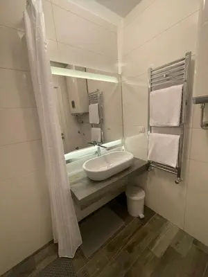 a white bathroom with a sink and a mirror at The Style, apartman sa parkingom in Belgrade