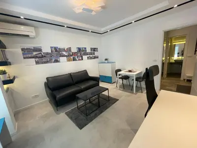 a living room with a black couch and a table at The Style, apartman sa parkingom in Belgrade