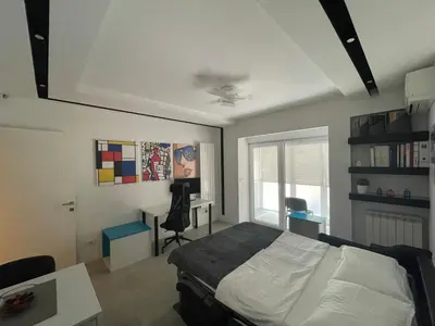 a bedroom with a bed and a desk and a window at The Style, apartman sa parkingom in Belgrade