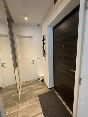 a hallway with a black door and a wooden floor at The Style, apartman sa parkingom in Belgrade