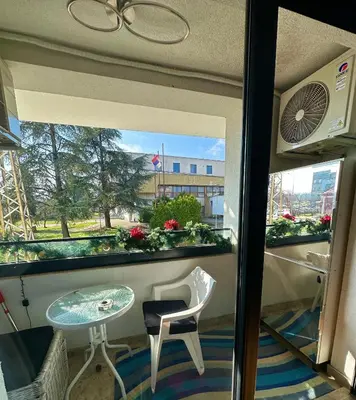 a balcony with a table and a chair and a window at Lux Tea Pancevo in Pančevo