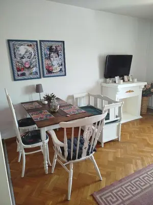 a dining room with a table and chairs and a tv at Gold Apartments in Belgrade