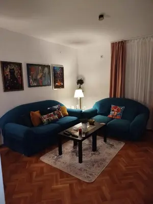 a living room with a blue couch and a coffee table at Gold Apartments in Belgrade