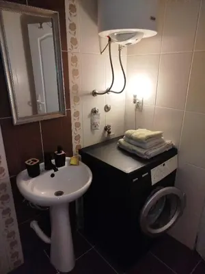 a bathroom with a sink and a washing machine at Gold Apartments in Belgrade