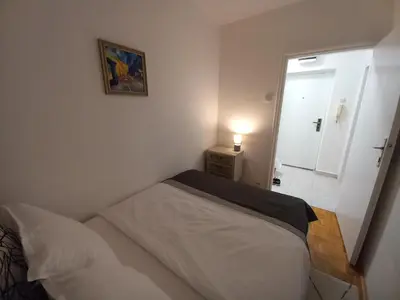 a small bedroom with a bed and a window at Pariske noći in Belgrade