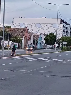 a person crossing a street with a car on the road at V Park Lux Apartman in Belgrade