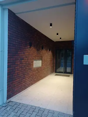 an empty room with a brick wall and a door at V Park Lux Apartman in Belgrade