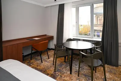 a hotel room with a bed and a table and chairs at Black Gallo Residences in Belgrade