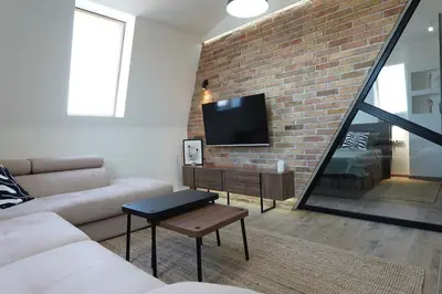a living room with a couch and a brick wall at Belgrade Cloud in Belgrade