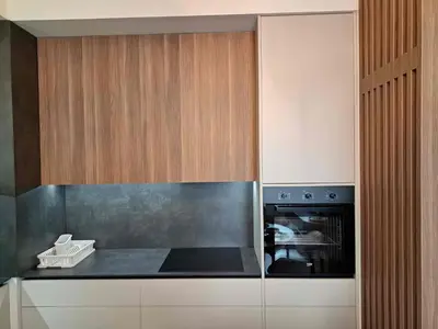 a kitchen with wooden cabinets and a stove at Apartment Belgrade Waterfront LUX -Libera 413 in Belgrade