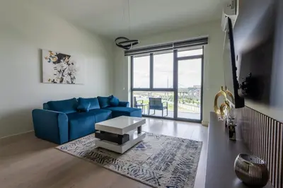 a living room with a blue couch and a table at Libera Luxe Residence in Belgrade