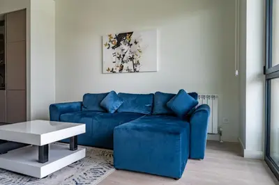 a living room with a blue couch and a table at Libera Luxe Residence in Belgrade
