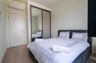a bedroom with a large bed with white sheets and pillows at Libera Luxe Residence in Belgrade