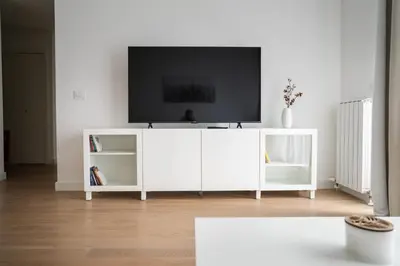 a white entertainment center with a tv on top of it at Terra river view in Sajmište