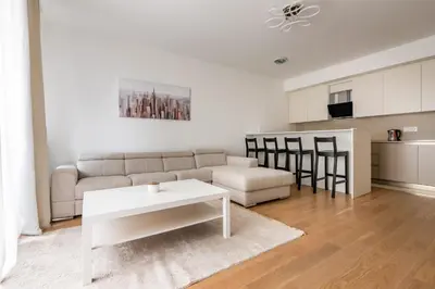 a white living room with a couch and a table at Terra river view in Sajmište