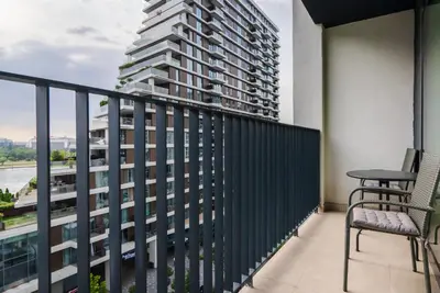 a balcony with a table and chair and a tall building at Terra river view in Sajmište