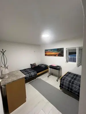 a room with two beds and a table in it at Kuca sa bazenom Oazis in Pećinci