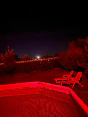 two red chairs and a table at night at Kuca sa bazenom Oazis in Pećinci