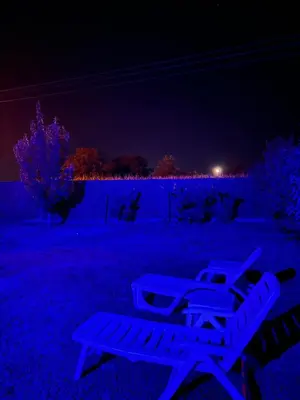 a couple of chairs sitting in a yard at night at Kuca sa bazenom Oazis in Pećinci