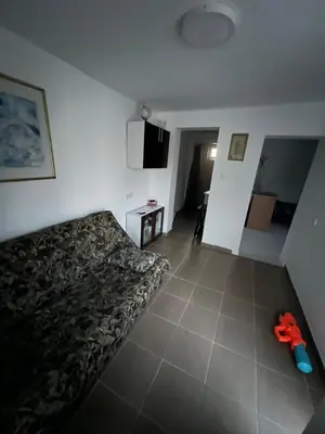 a living room with a bed and a tiled floor at Kuca sa bazenom Oazis in Pećinci