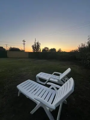 a couple of white lawn chairs sitting in a yard at Kuca sa bazenom Oazis in Pećinci