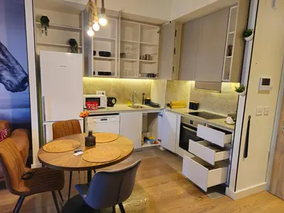 a small kitchen with a table and a refrigerator at ARTA LUX - Galerija Beograd na vodi - Belgrade Waterfront in Belgrade