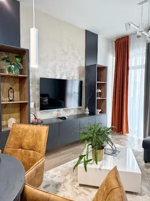 a living room with a television and a table and chairs at ARTA LUX - Galerija Beograd na vodi - Belgrade Waterfront in Belgrade