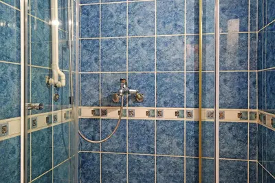 a bathroom with a shower with blue tiles at Skadarlija discovery Beograd centar lux in Belgrade
