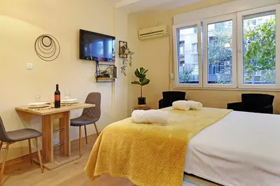 a room with a bed and a table and a tv at Skadarlija discovery Beograd centar lux in Belgrade