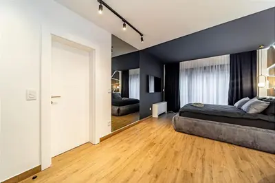 a bedroom with a king sized bed and a sliding door at Dark Nest 1 Belgrade Apartments in Zvezdara