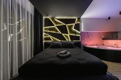 a bedroom with a black bed and a bath tub at Dark Nest 1 Belgrade Apartments in Zvezdara