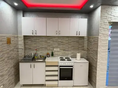 a kitchen with white cabinets and a stove at Infinity Apartman Obrenovac, sa parkingom privatnim in Obrenovac