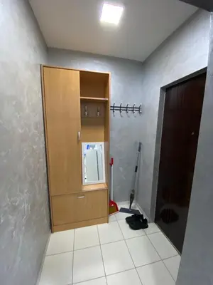 a room with a wooden cabinet and a mop at Infinity Apartman Obrenovac, sa parkingom privatnim in Obrenovac