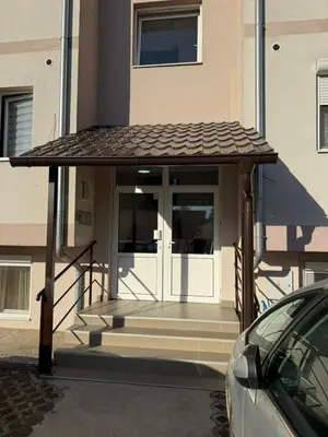 a building with a porch with a glass door at Infinity Apartman Obrenovac, sa parkingom privatnim in Obrenovac