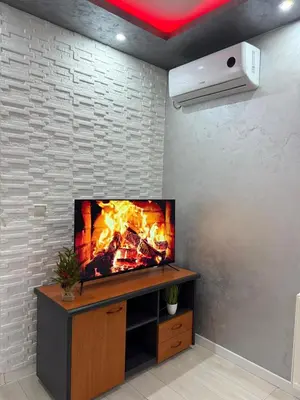 a flat screen tv on a wall with a fireplace at Infinity Apartman Obrenovac, sa parkingom privatnim in Obrenovac
