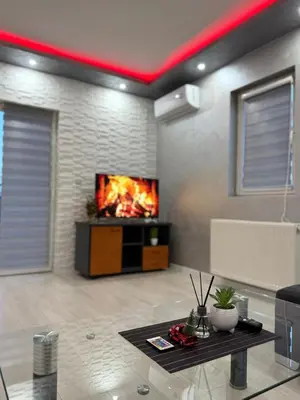 a living room with a tv on a wall at Infinity Apartman Obrenovac, sa parkingom privatnim in Obrenovac