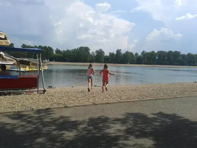 two children walking on the beach near the water at Apartment Vracar in Belgrade