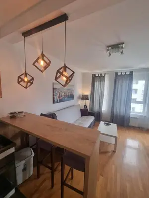 a living room with a table and a couch at Laguna in Bežanija