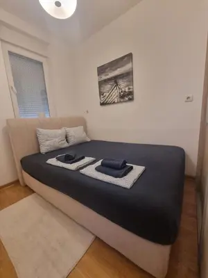a bedroom with a bed with a black and white mattress at Laguna in Bežanija