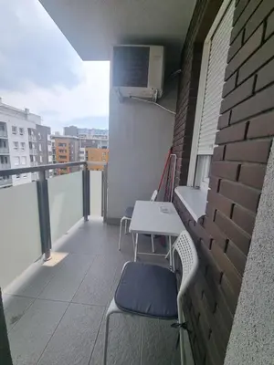 a balcony with two chairs and a table on a building at Laguna in Bežanija