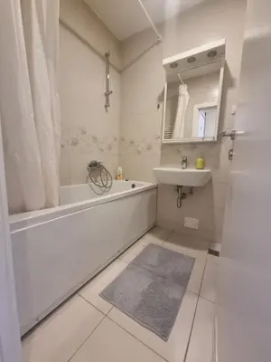 a white bathroom with a tub and a sink at Laguna in Bežanija