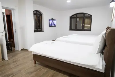 a bedroom with two white beds and a wooden floor at Smestaj Centar Ub 35 in Ub