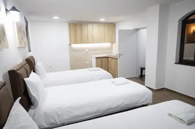 two beds in a room with white sheets at Smestaj Centar Ub 35 in Ub