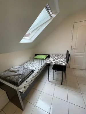a bed in a room with a table and a window at Travel Home in Belgrade