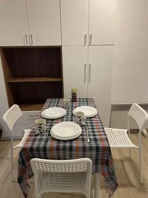 a dining room table with plates and cups and chairs at Travel Home in Belgrade
