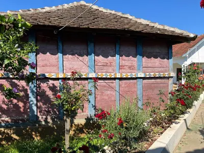 a red and blue building with flowers in a garden at La Corte Delle Rose UB in Ub