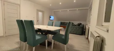 a dining room with a table and green chairs at Miki Private Room in Belgrade