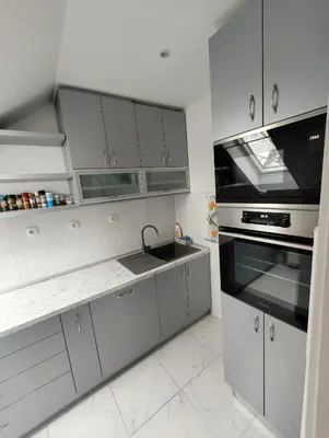 a white kitchen with a sink and a stove at Miki Private Room in Belgrade