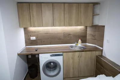 a small bathroom with a washing machine and a sink at Apartman Centar 18 in Ub